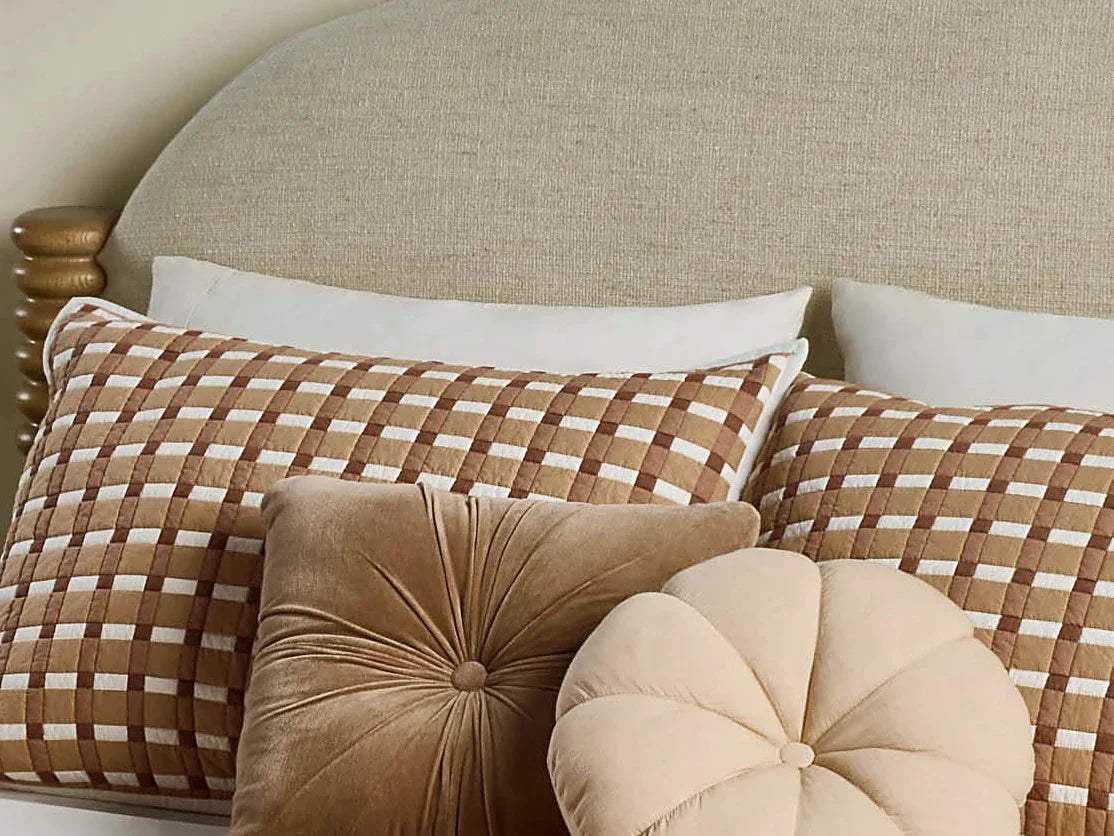 Pillows and a quilted gingham bed seen close up