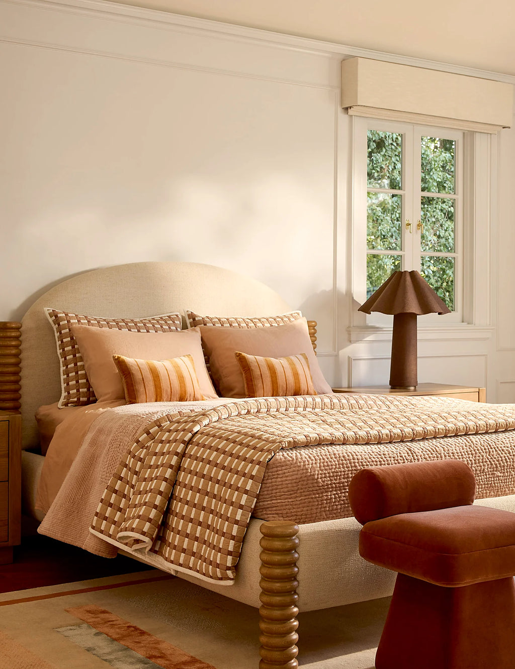 Bedroom with a gingham cotton quilt draped as the top layer