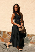 Front view of a black midi dress with a woven round buckle at the front