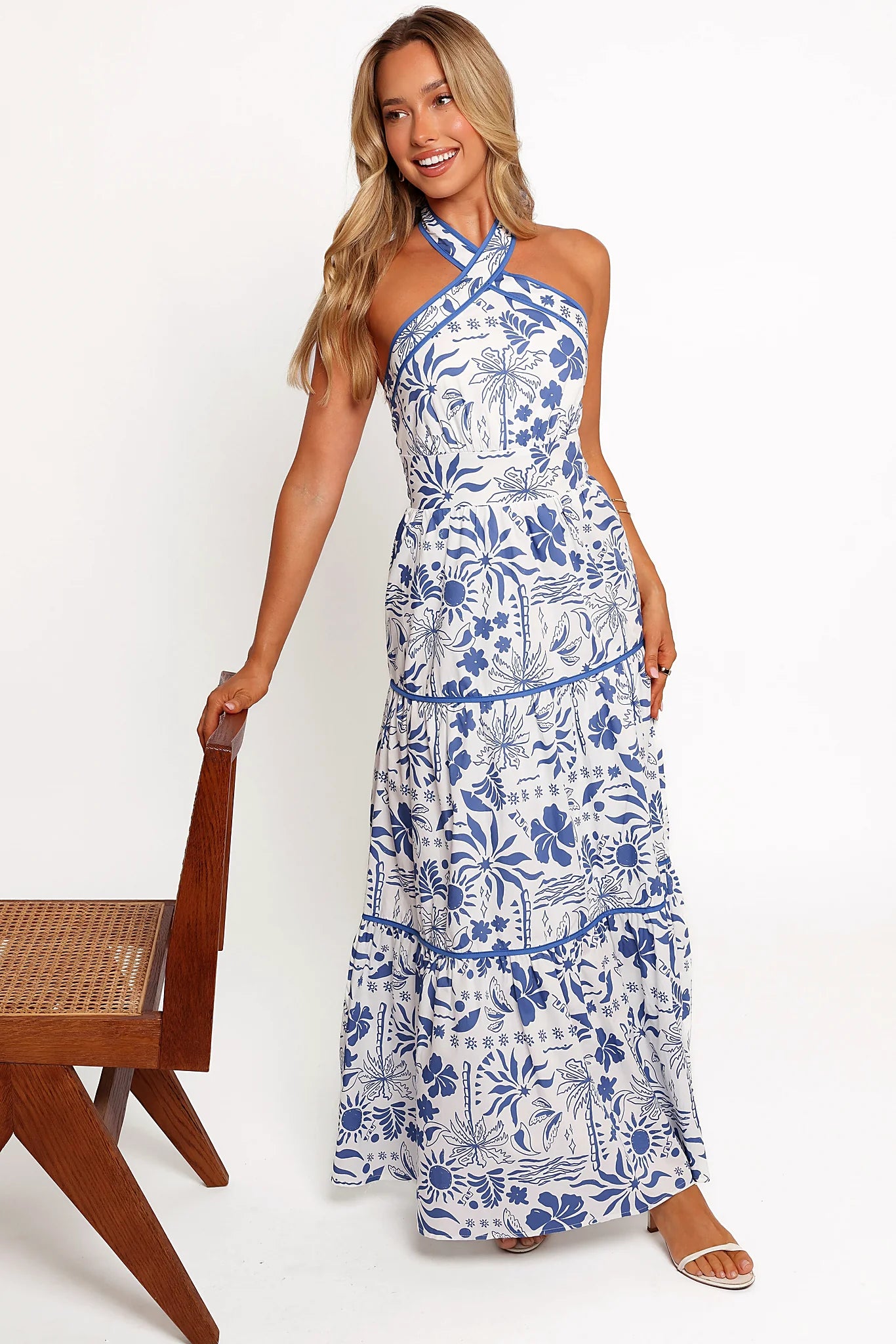Front view of a blue tropical print maxi dress with a halter neckline