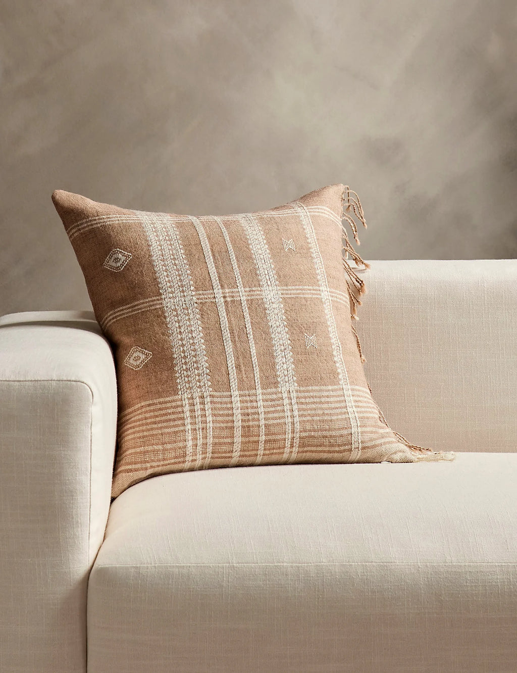 Hand loomed wool pillow with a geometric weave set on a sofa