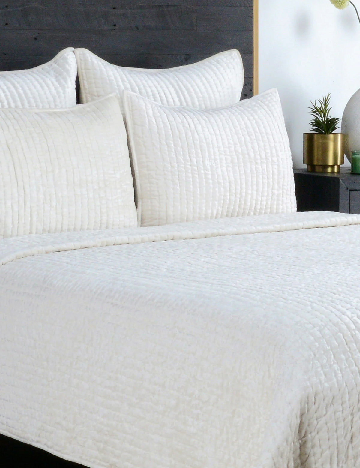 Velvet quilt with linear quilting shown across a made bed