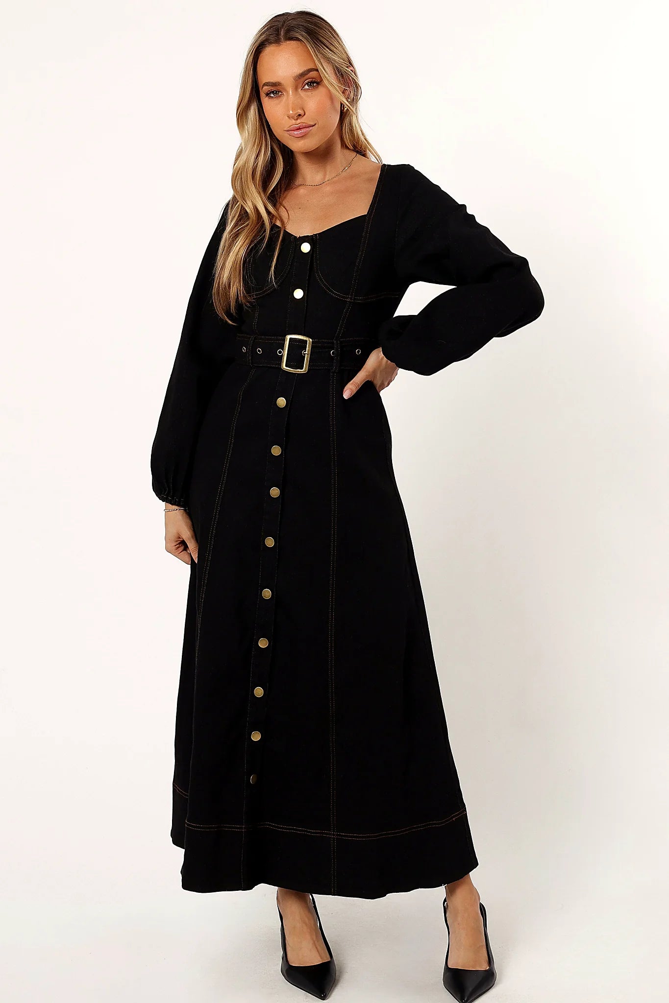 Front view of a black maxi dress with a buckle belt at the waist