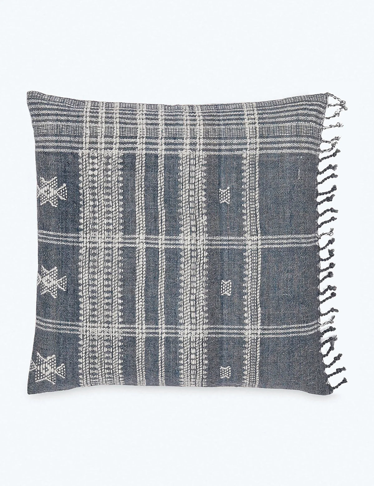 Slate wool pillow with knotted fringe set against a plain ground