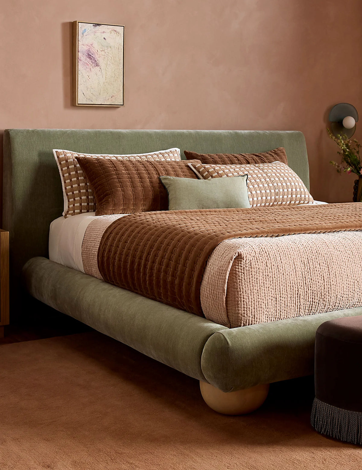 Spring bedding scene with a quilted velvet sham layered over pillows