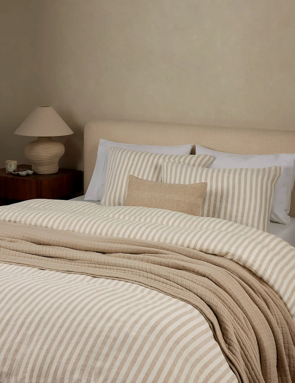 Striped linen bedding shown across a made bed in full queen size