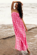 Front view of a strapless maxi dress in a pink and red abstract print
