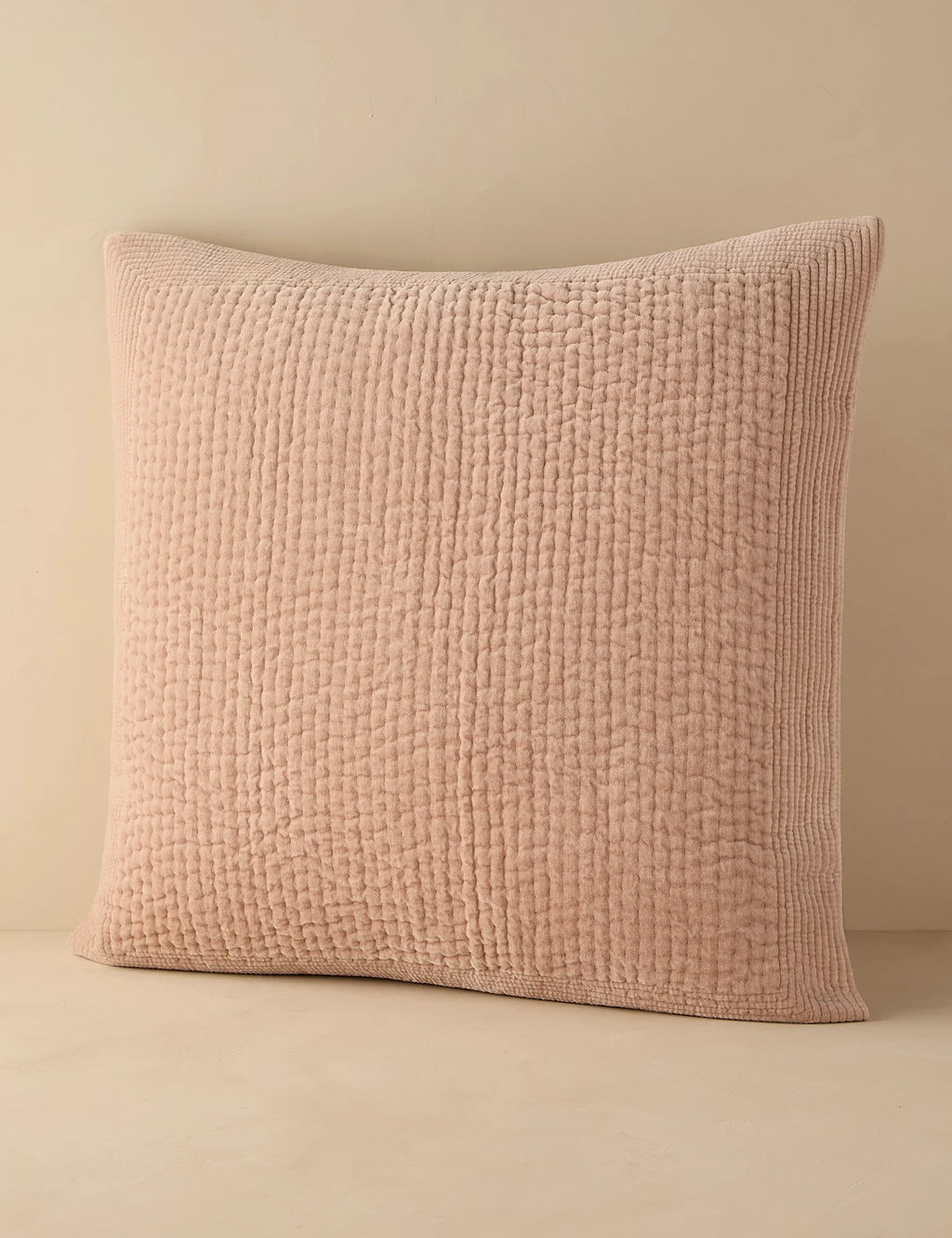 Blush quilted velvet sham in euro size against a plain ground