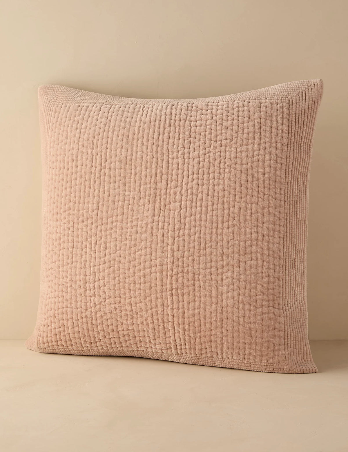 Blush quilted velvet sham in euro size against a plain ground