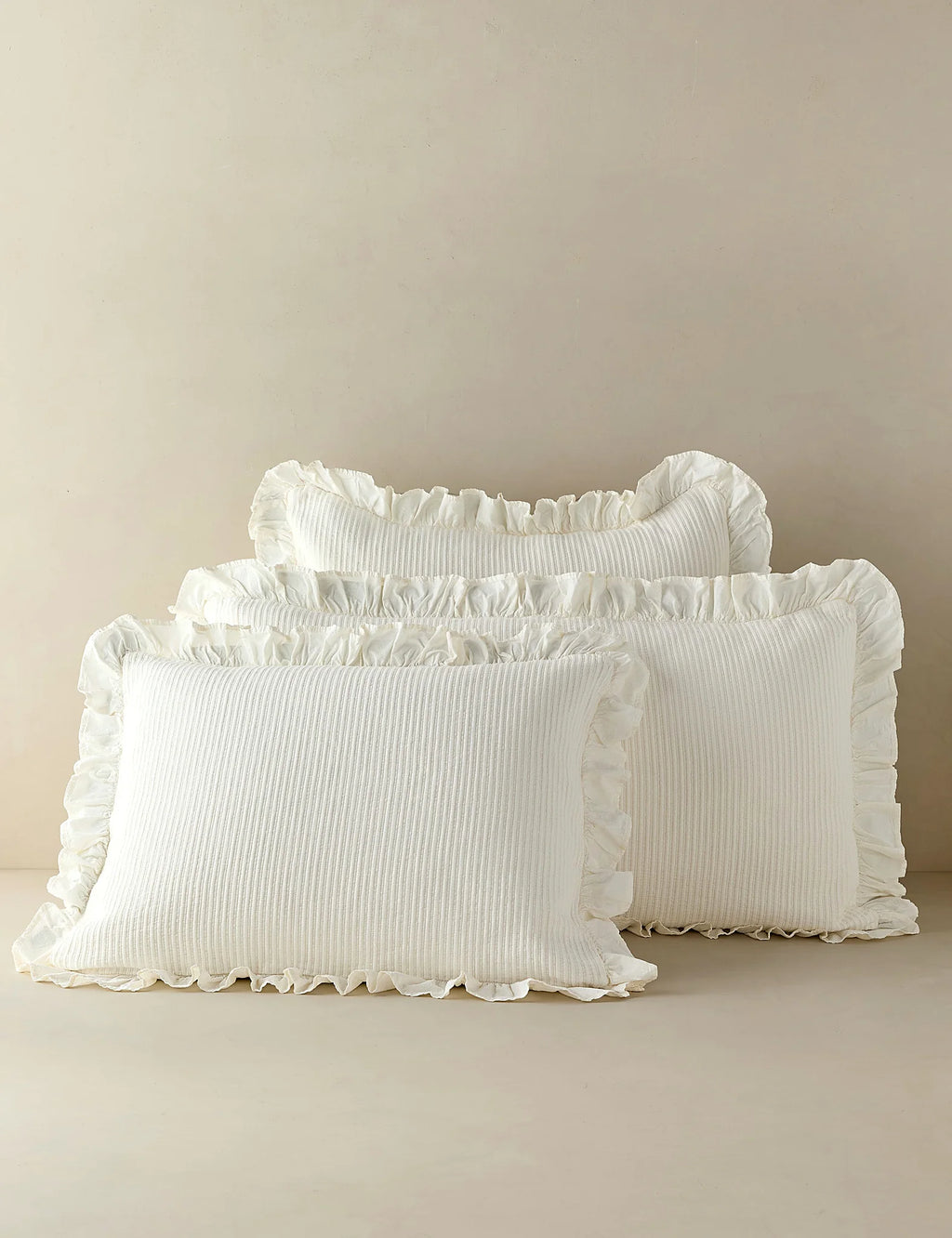 Group shot of ivory cotton shams in two sizes