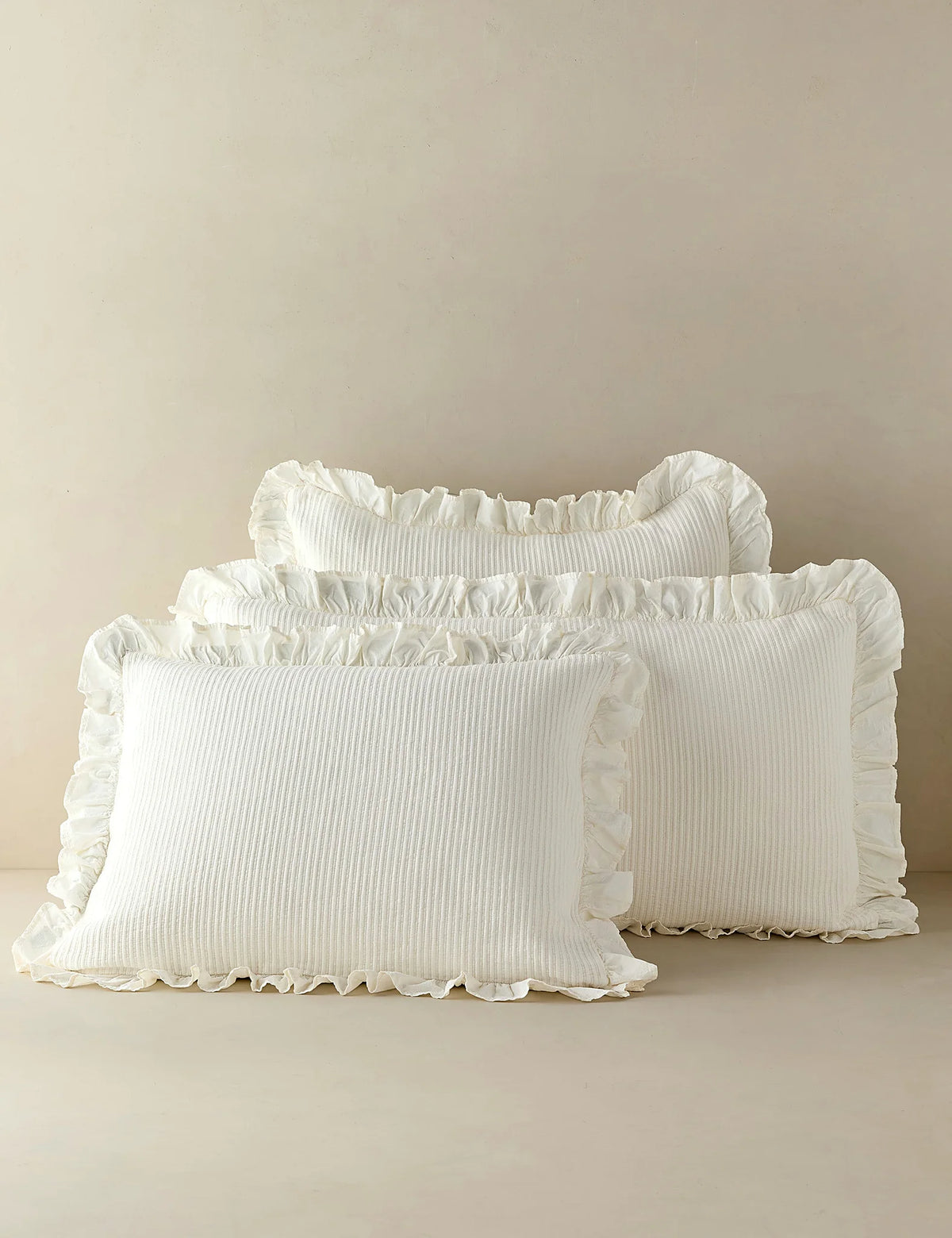 Group shot of ivory cotton shams in two sizes